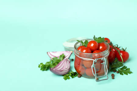 Jar with pickled tomatoes and ingredients on mint backgroundの写真素材