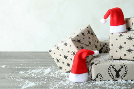 Santa hats and gift boxes on gray textured tableの写真素材