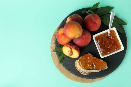 Sandwich with peach jam and ingredients on mint background