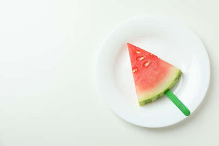 Ice stick with watermelon slice on plate on white background