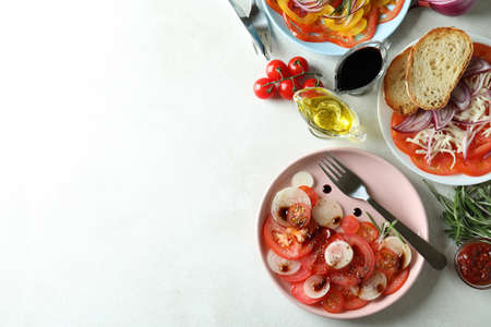 Concept of tasty food with tomato carpaccio on white textured tableの写真素材