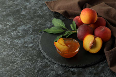 Peach jam and ingredients on black smokey tableの写真素材