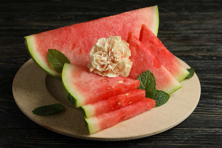 Wooden board with watermelon slices, mint leaves and flowerの写真素材