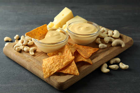 Concept of snack with cheese sauce on dark wooden table