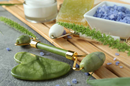 Skin care beauty concept with face rollers on gray textured backgroundの写真素材