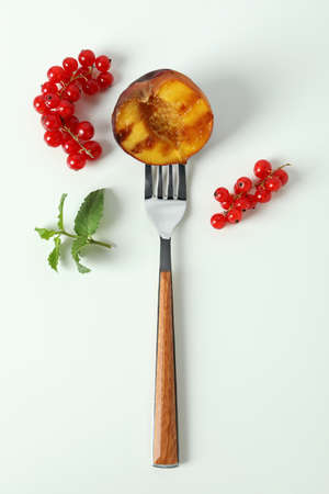 Fork with grilled peach on white backgroundの写真素材