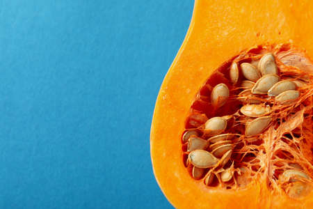 Half of raw pumpkin on blue background