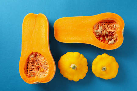 Raw pumpkins on blue background, top view