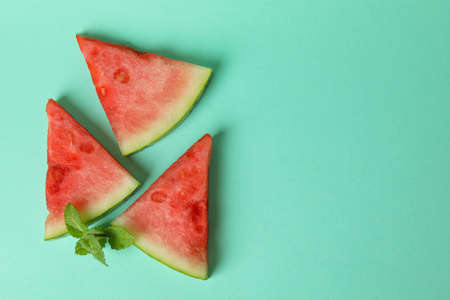 Watermelon slices and mint on mint background