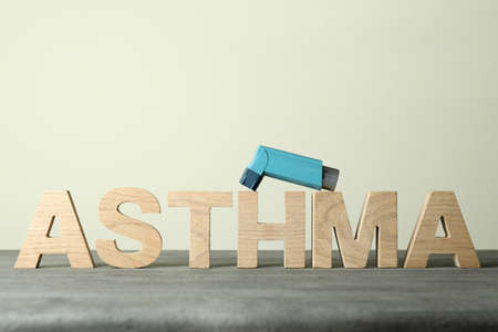 Text Asthma made of wooden letters and inhaler against beige backgroundの写真素材