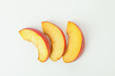 Slices of peach fruit isolated on white backgroundの写真素材