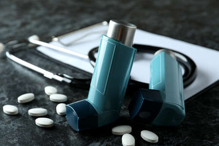 Asthma treatment accessories on black smokey tableの写真素材