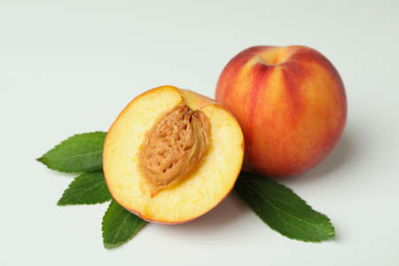 Ripe peach fruits with leaves on white backgroundの写真素材