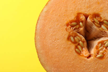 Melon half on yellow background, close up