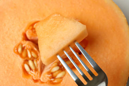 Fork with melon piece, close up and selective focusの写真素材