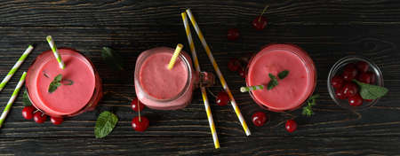 Cherry smoothie and ingredients on rustic wooden tableの写真素材