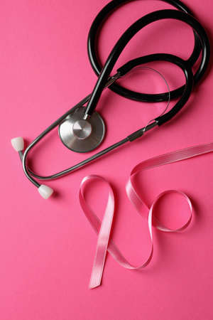 Breast cancer awareness ribbon and stethoscope on pink backgroundの写真素材