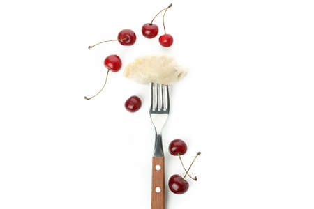 Fork with pierogi with cherry isolated on white backgroundの写真素材