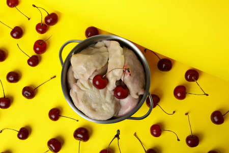 Pot with pierogi with cherry on yellow backgroundの写真素材