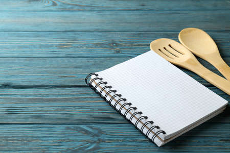 Empty recipe book and utensils on wooden tableの写真素材