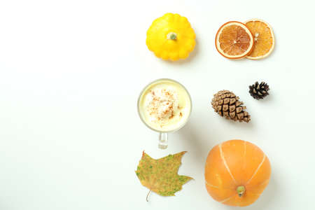 Glass of pumpkin latte and ingredients on white backgroundの写真素材