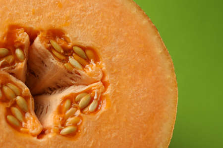 Melon half on green background, close up