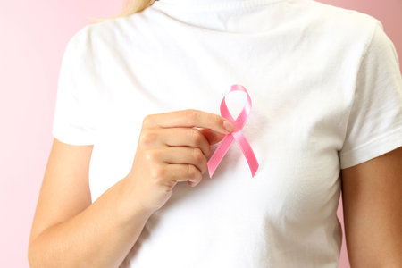 Young woman holds breast cancer awareness ribbon, close upの写真素材
