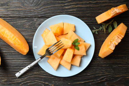 Concept of fresh food with melon pieces on rustic wooden tableの写真素材