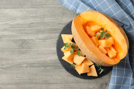 Bowl with melon pieces on gray textured tableの写真素材