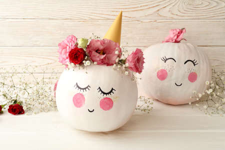Ð¡ute pumpkins with halloween makeup on white wooden backgroundの写真素材
