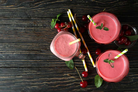 Cherry smoothie and ingredients on rustic wooden tableの写真素材