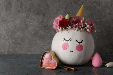 Ð¡ute pumpkin with halloween makeup against gray textured backgroundの写真素材
