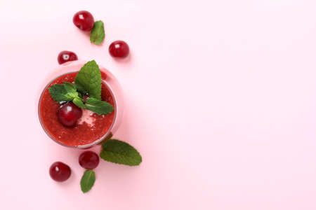 Glass of cherry smoothie and ingredients on blue backgroundの写真素材