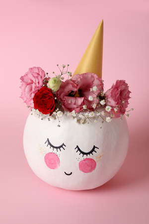 Ð¡ute pumpkin with halloween makeup on pink backgroundの写真素材