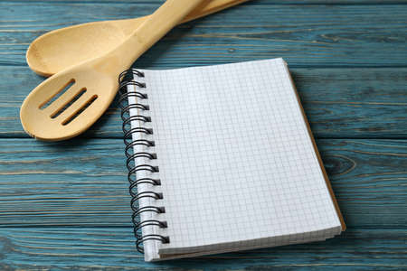 Empty recipe book and utensils on wooden tableの写真素材