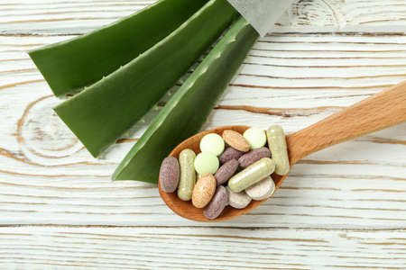 Concept of herb pills with aloe on white wooden backgroundの写真素材