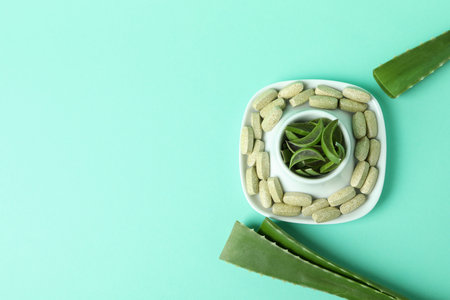 Concept of herb pills with aloe on mint backgroundの写真素材