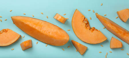 Ripe melon slices on blue background, top viewの写真素材