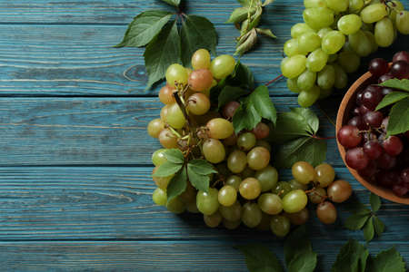 Bowl with red grape and green grape on wooden background