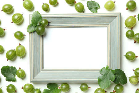 Empty photo frame and gooseberry on white backgroundの写真素材