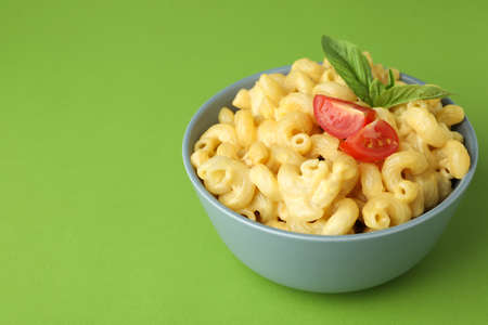 Plate with macaroni and cheese on green backgroundの写真素材