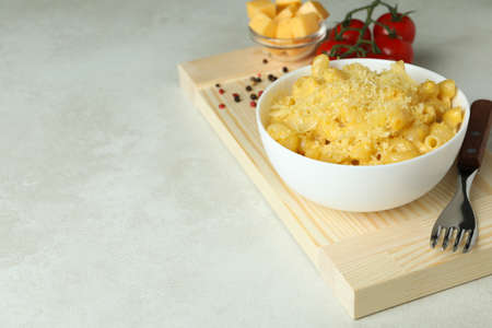 Concept of tasty eating with macaroni with cheese on white textured table