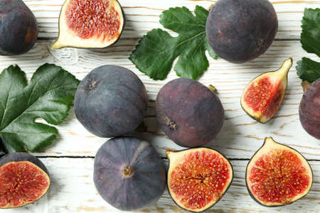 Fig with leaves on white wooden background
