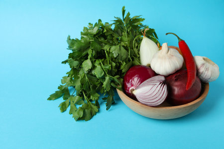 Bowl with spicy vegetables and parsley on blue backgroundの写真素材