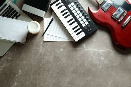Musician workplace on gray textured table, space for text