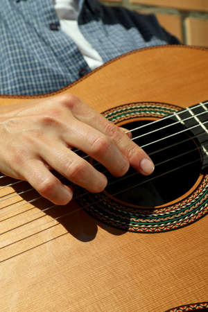 Woman in shirt playing on classical guitar