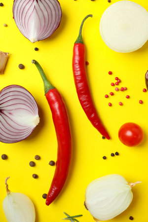 Different spicy vegetables on yellow background, top viewの写真素材