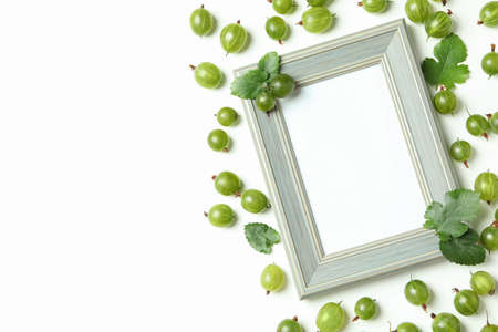 Empty photo frame and gooseberry on white backgroundの写真素材