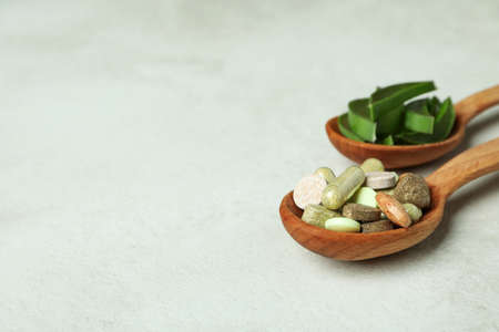 Concept of herb pills with aloe slices on white textured backgroundの写真素材