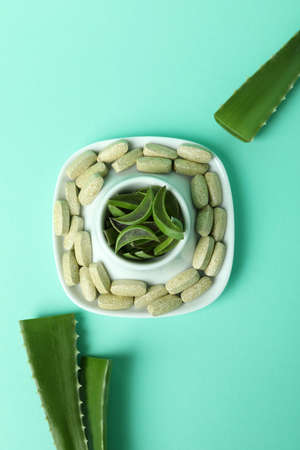 Concept of herb pills with aloe on mint backgroundの写真素材
